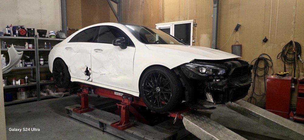Witte Mercedes CLA met zijschade opgesteld op de richtbank
